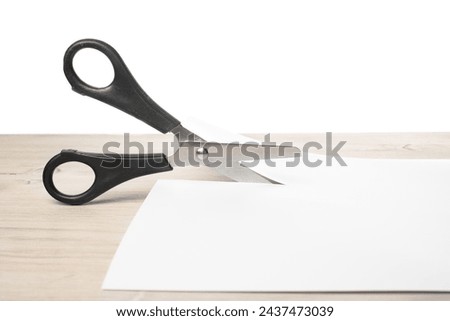Paper cutting with scissors. A layout of a blank sheet of paper for assignments, a presentation of the design of paper crafts, a template. Royalty-Free Stock Photo #2437473039