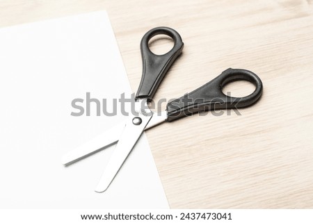Paper cutting with scissors. A layout of a blank sheet of paper for assignments, a presentation of the design of paper crafts, a template. Royalty-Free Stock Photo #2437473041