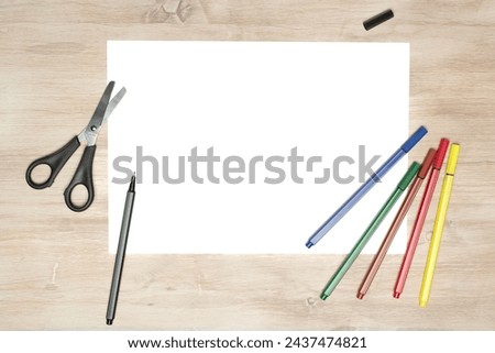 Paper cutting with scissors. A layout of a blank sheet with markers, paper for assignments, a presentation of the design of paper crafts, a template. Royalty-Free Stock Photo #2437474821