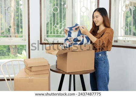Asian Female Standing with Opened Cartoon Box, Unboxing Product from Online Store with Happy Face. Online Shopping Concept Royalty-Free Stock Photo #2437487775