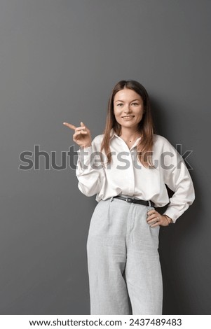 Professional woman in smart attire gesturing to space for text.