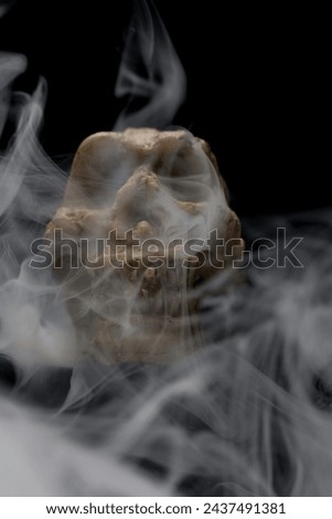 Homemade scary skull with menacing eyes with unique fog and mist patterns swirling round the skull created and made by photographer
