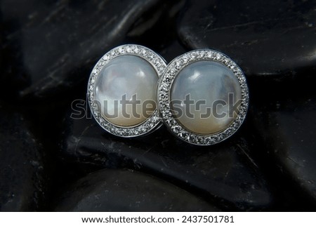 Pearl earrings with diamond surround on black stones