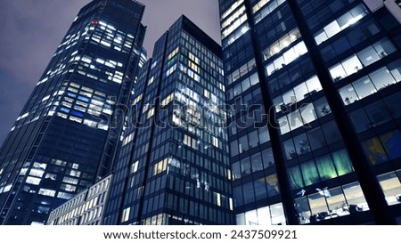 Office buildings by night. Night architectural, buildings with glass facade. Modern buildings in business district. Concept of economics, financial.