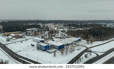 Drone photography of city landscape covered by snow during winter cloudy day
