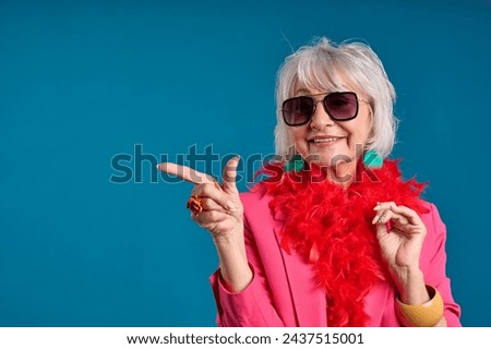 Stylish Senior Woman Pointing with a Smile Royalty-Free Stock Photo #2437515001