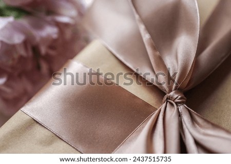 Bouquet of pink tulips and a gift box with a bow, festive concept.