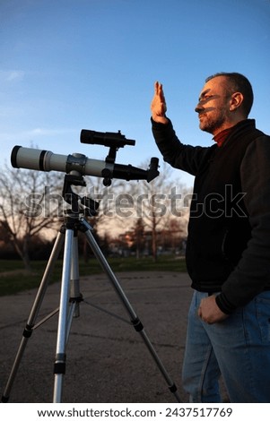 Amateur astronomer observing Sun eclipse and Sun with a telescope and special solar filter. Royalty-Free Stock Photo #2437517769