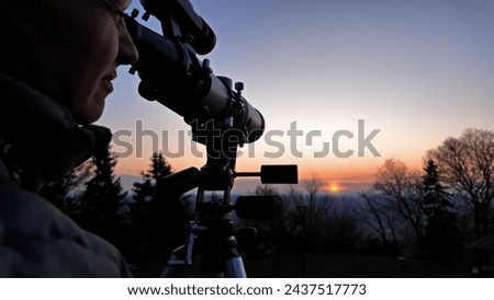 Amateur astronomer observing Sun eclipse and Sun with a telescope and special solar filter. Royalty-Free Stock Photo #2437517773