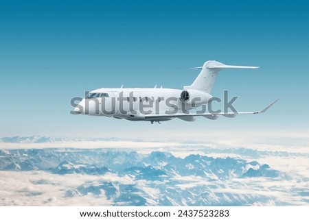 White modern luxury executive aircraft fly over snow covered mountains Royalty-Free Stock Photo #2437523283