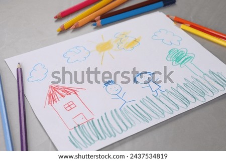 Cute child`s drawing and colorful pencils on grey textured table