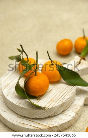 Small orange or tangarine on brown background. Jeruk Royalty-Free Stock Photo #2437543065