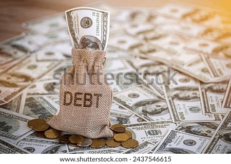 Financial debt concept. A man hand on stack of coins and money bag showing about debt.