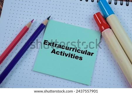Concept of Extracurricular Activities write on sticky notes isolated on Wooden Table.