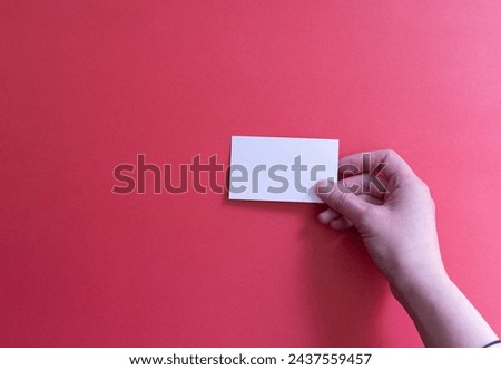 person's hand holding a white card