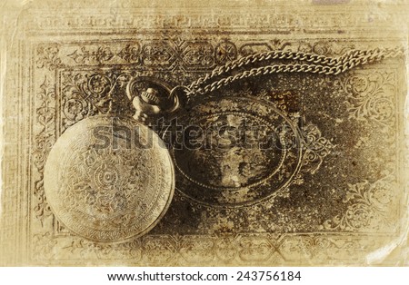 macro image of old vintage pocket watch on antique book. top view. old style photo