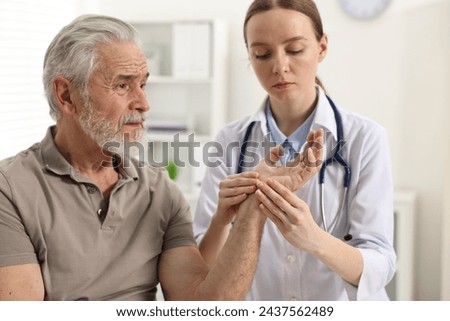 Arthritis symptoms. Doctor examining patient's hand in hospital Royalty-Free Stock Photo #2437562489