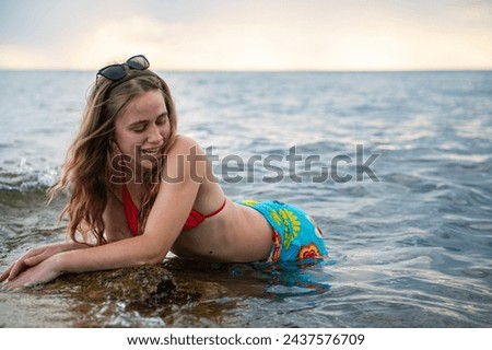 A young, beautiful woman relaxes in the water of the Adriatic Sea in Croatia - the horizon over the sea
