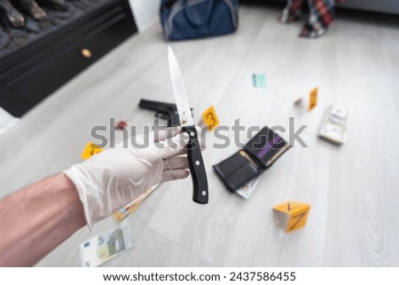 Close up on hands of unknown man forensic police investigator collecting evidence in the plastic bag at the crime scene investigation Royalty-Free Stock Photo #2437586455