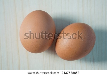 Two chicken eggs on wooden background