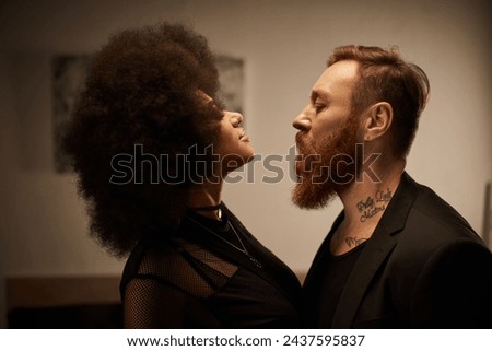 curly african american woman in chic dress seducing tattooed boyfriend with beard, date night Royalty-Free Stock Photo #2437595837