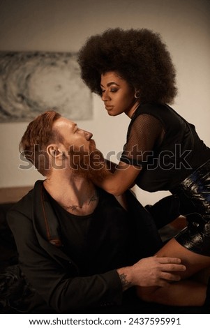 Romantic evening of stylish couple in an intimate setting, african american woman seducing man Royalty-Free Stock Photo #2437595991