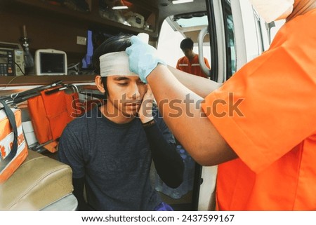 Medical team rescue workers Volunteer workers work team leading ambulance to care injured man in a car accident highway had head injury and received first aid until he was safe and was taken hospital. Royalty-Free Stock Photo #2437599167