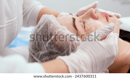 Side view portrait of young attractive woman on procedure for improvements skin. Concept of special masks and creams for moisturizing and improving the skin. Royalty-Free Stock Photo #2437600311