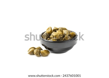 Capers  isolated on a white background. Marinated caper buds, small salted capparis in bowl, fermented food, pickled capers group.Organic spices and seasonings. Royalty-Free Stock Photo #2437601001