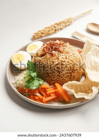 Fried rice served on a plate with vegetable salad, crackers and boiled eggs, with a portait concept