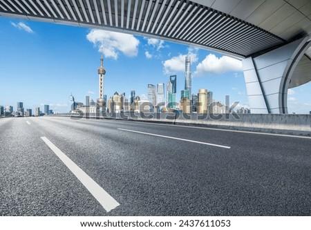 Asphalt highway road and pedestrian bridge with modern city buildings in Shanghai