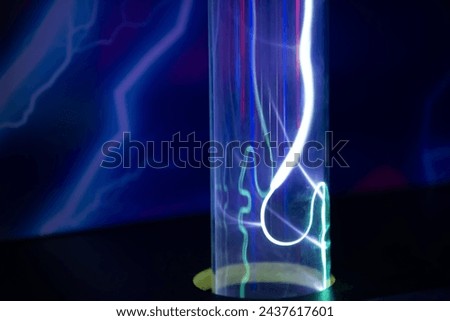 A purple and blue glowing tube with a red line running through it. The tube is lit up and he is a neon light Royalty-Free Stock Photo #2437617601