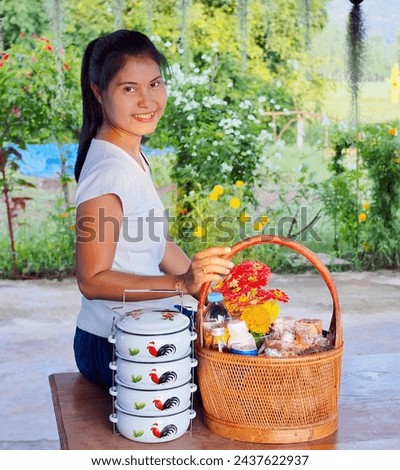 Thai women smile brightly and happily with lunchboxes and baskets of food to make merit at the temple. I have tan skin and am petite. I like taking pictures and am very happy with a beautiful smile.