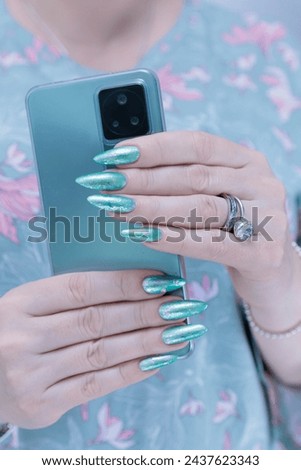 Woman's hands holding a large black smartphone