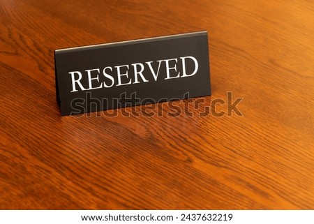 There is a sign on the wooden table indicating that this is a reserved seat.