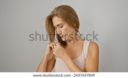 Mature blonde woman in contemplation, isolated on a white background, embodying timeless beauty and introspection.
