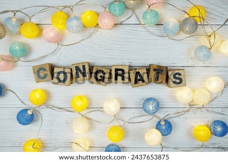 Congrats alphabet letters with LED cotton balls decoration on wooden background
