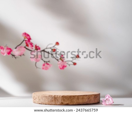 empty wooden podium stand for product presentation with pink flowers.