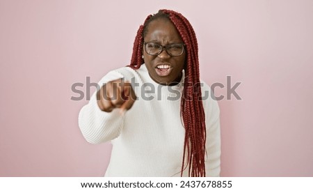 Angry african american woman with braids pointing finger over isolated pink background Royalty-Free Stock Photo #2437678855