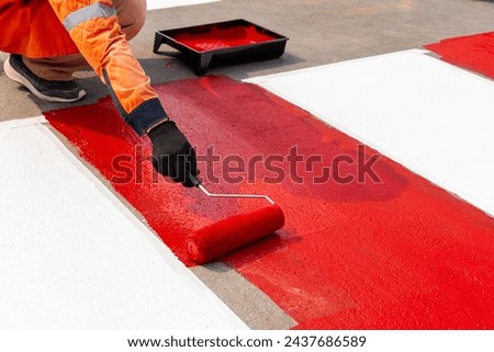 Workers are painting a pedestrian crossing. Royalty-Free Stock Photo #2437686589