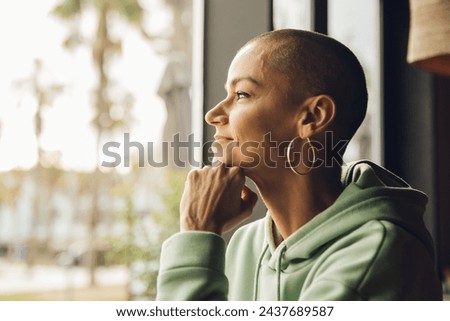 Happy woman looking through the window with relaxed and happy Royalty-Free Stock Photo #2437689587