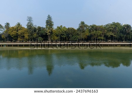 Beautiful Ramna park with lake, trees and side walkway. Dhaka, Bangladesh Royalty-Free Stock Photo #2437696163