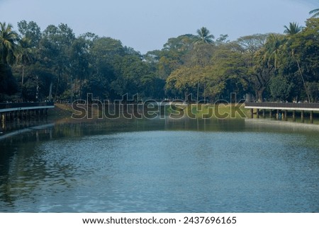 Beautiful Ramna park with lake, trees and side walkway. Dhaka, Bangladesh Royalty-Free Stock Photo #2437696165