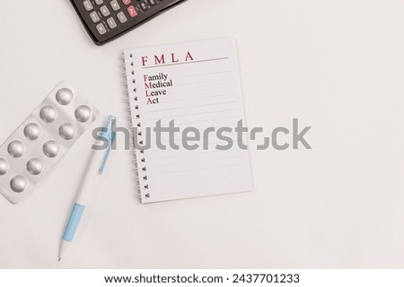 Office scene with notebook with text "FMLA; Family Medical Leave Act" neatly placed on a desk Royalty-Free Stock Photo #2437701233