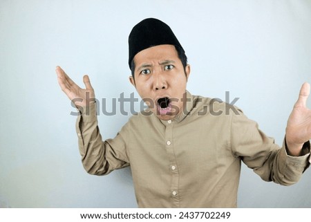 funny facial expression shock and confuse asian muslim men wearing cap isolated on white background