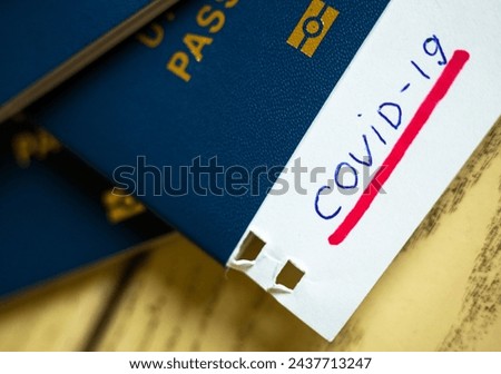 Passport and note with Covid-19 inscription. Coronavirus disease outbreak. Travelling in epidemic period. Passport border control and quarantine of infected tourists. Royalty-Free Stock Photo #2437713247