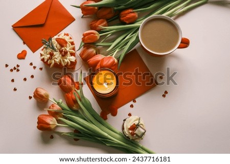 Candle and bouquet of red tulips, spring aesthetics.