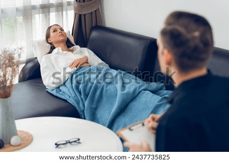 Stressed and depressed patient seeking help from psychiatrist with mental illness and depression in office during mental therapy session. Mental health treatment and medical care concept. Unveiling Royalty-Free Stock Photo #2437735825