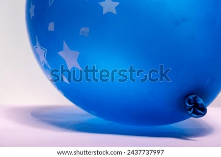 Close up of blue balloon on pink background after party