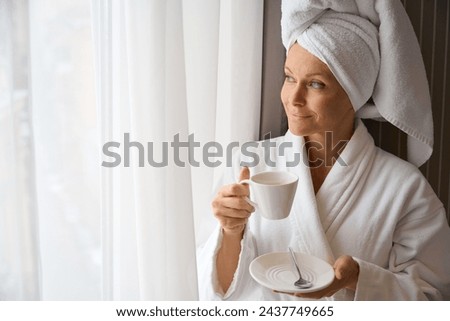 Pleased lady enjoying view from her bedchamber over morning coffee Royalty-Free Stock Photo #2437749665